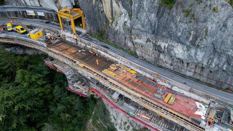 Luftaufnahme der Baustelle: Eine Fahrspur bleibt f&uuml;r den Verkehr offen, w&auml;hrend auf der Seeseite mit Schutzger&uuml;st und enger Logistik das Lehnenbauwerk entsteht. Das ist millimetergenaue Arbeit auf sehr kleinem Raum.