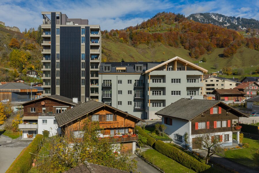Das neue Wohnhochhaus gegen&uuml;ber zeigt die Weiterentwicklung des Areals. Die integrierte Photovoltaikfassade liefert Strom und pr&auml;gt mit ihren vertikalen Modulen das heutige Erscheinungsbild. Bild: Ritter Schumacher AG