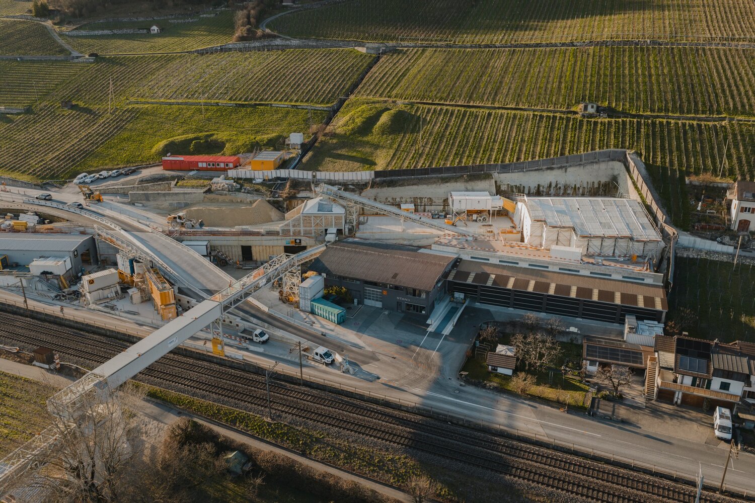 Luftaufnahme der Baustelle f&uuml;r den Doppelspurausbau zwischen Neuenstadt, Ligerz und Twann am Bielersee. Das Projekt umfasst den Bau eines 2,13 Kilometer langen Bahntunnels und liegt in einer landschaftlich und kulturell besonders sensiblen Region mit national gesch&uuml;tzten Ortsbildern und Landschaften. Das Projekt kombiniert die Disziplinen Tunnelbau, Ingenieurbau, Spezialtiefbau, Seearbeiten und Bahntechnik. &copy; SBB CFF FFS, Stand 03.2026.